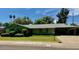 Single-story home with green paint, carport, lush lawn, and established trees at 333 W Seldon Ln, Phoenix, AZ 85021