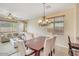 Bright dining area features a chandelier and seamless transition to the living room with a comfortable sofa at 36199 W Prado St, Maricopa, AZ 85138