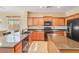 Modern kitchen with black appliances, granite countertops, and a breakfast bar at 36199 W Prado St, Maricopa, AZ 85138