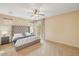 Bright bedroom with a plush carpet, stylish gray headboard, two bedside tables, and natural light streaming through the windows at 36199 W Prado St, Maricopa, AZ 85138