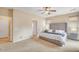 Spacious main bedroom showcasing a tufted headboard, neutral tones, and access to ensuite bathroom and walk in closet at 36199 W Prado St, Maricopa, AZ 85138