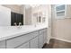 Bright bathroom with double sink vanity, spacious mirror, wood look floors, and walk in shower at 40816 W Sunland Dr, Maricopa, AZ 85138