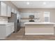 Spacious kitchen featuring stainless steel appliances, grey cabinets, and an island with a sink at 40816 W Sunland Dr, Maricopa, AZ 85138