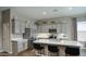 A modern kitchen featuring an island with bar seating, stainless steel appliances, and shaker style cabinets at 40816 W Sunland Dr, Maricopa, AZ 85138