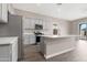 Spacious kitchen featuring stainless steel appliances, grey cabinets, and an island with a sink at 40816 W Sunland Dr, Maricopa, AZ 85138