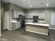 Spacious kitchen with gray cabinets, stainless steel appliances, and large white quartz island at 40816 W Sunland Dr, Maricopa, AZ 85138