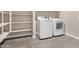 Convenient laundry room features tile flooring, shelving, and modern, brand-new washer and dryer at 40816 W Sunland Dr, Maricopa, AZ 85138