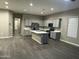 Open-concept living space featuring a kitchen with a large island and wood-look flooring throughout at 40816 W Sunland Dr, Maricopa, AZ 85138