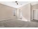Spacious carpeted main bedroom with ceiling fan, offering a relaxing retreat with access to the bathroom at 40816 W Sunland Dr, Maricopa, AZ 85138