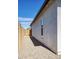 A narrow side yard with gravel, a block wall and a gate, providing a clean and low-maintenance outdoor space at 40816 W Sunland Dr, Maricopa, AZ 85138