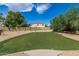 Private backyard putting green with lush landscaping and blue sky views at 4241 N Pebblecreek Pkwy # 7, Goodyear, AZ 85395
