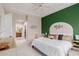 Comfortable bedroom featuring a striking green accent wall and neutral decor at 4241 N Pebblecreek Pkwy # 7, Goodyear, AZ 85395