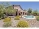 Desert landscaped backyard with a unique shaped pool, covered patio and desert flowers at 4293 S Columbine Way, Gold Canyon, AZ 85118