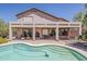 Inviting backyard featuring a covered patio, a sparkling pool with a cleaner, and a tranquil fountain at 4293 S Columbine Way, Gold Canyon, AZ 85118