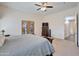 Spacious bedroom with carpet flooring, ceiling fan, balcony access, and a wooden dresser with a TV at 44421 N 12Th St, New River, AZ 85087