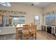 Bright dining area with wood table, chairs and windows overlooking desert landscape at 44421 N 12Th St, New River, AZ 85087