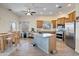 Bright kitchen with stainless steel appliances, wood cabinets, and a center island with breakfast bar at 44421 N 12Th St, New River, AZ 85087