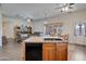 Open-concept kitchen with stainless steel appliances, dark countertops, and an island bar at 44421 N 12Th St, New River, AZ 85087