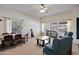 Bright living room boasts large windows, neutral carpeting, ceiling fan, and traditional furnishings at 44421 N 12Th St, New River, AZ 85087