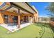 A covered patio with a table and chairs and artificial grass at 44421 N 12Th St, New River, AZ 85087