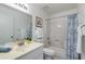 Bathroom with granite vanity, mirror, and a blue and white patterned shower curtain at 446 S 77Th St, Mesa, AZ 85208
