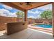 Outdoor patio featuring a built-in grill and small pool with a waterfall in a well-kept backyard at 45309 W Gavilan Dr, Maricopa, AZ 85139