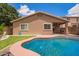Charming backyard with a pool, manicured lawn, covered patio, and comfortable seating at 45309 W Gavilan Dr, Maricopa, AZ 85139