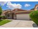 Beautiful single-story home featuring lush landscaping, a well-manicured lawn, and a Southwestern-style facade with a tile roof at 45309 W Gavilan Dr, Maricopa, AZ 85139