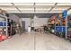 Spacious two car garage with organized shelving, overhead lighting, and concrete flooring at 45309 W Gavilan Dr, Maricopa, AZ 85139