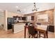 The kitchen with stainless appliances, a central island, and a dining area featuring a brick wall at 45309 W Gavilan Dr, Maricopa, AZ 85139