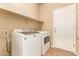 Well-lit laundry room featuring a modern washer and dryer set with a built in shelf above at 45309 W Gavilan Dr, Maricopa, AZ 85139