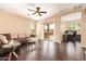 Spacious living room with dark wood floors, ceiling fan, and sliding glass doors to patio at 45309 W Gavilan Dr, Maricopa, AZ 85139