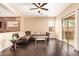 Bright living room showcasing dark wood flooring, ceiling fan, and sliding glass doors to backyard at 45309 W Gavilan Dr, Maricopa, AZ 85139