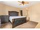 Spacious main bedroom featuring a ceiling fan, carpet floors and ensuite bath access at 45309 W Gavilan Dr, Maricopa, AZ 85139