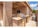Outdoor grill and bar area on the patio with tan stucco and views of the yard at 45309 W Gavilan Dr, Maricopa, AZ 85139