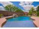 Inviting backyard pool surrounded by lush landscaping and a tranquil waterfall feature at 45309 W Gavilan Dr, Maricopa, AZ 85139