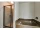Bathroom featuring a sleek glass-enclosed shower and a deep soaking tub with decorative stone surround at 5350 E Deer Valley Dr # 1433, Phoenix, AZ 85054