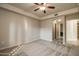 Inviting bedroom with neutral carpet, ceiling fan, and arched doorways leading to other rooms at 5350 E Deer Valley Dr # 1433, Phoenix, AZ 85054