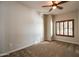 Cozy bedroom with carpeted floors, wood-shuttered window, and a modern ceiling fan at 5350 E Deer Valley Dr # 1433, Phoenix, AZ 85054