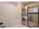 Efficient laundry room with stacked washer/dryer unit and a compact refrigerator at 5350 E Deer Valley Dr # 1433, Phoenix, AZ 85054