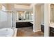 Bright bathroom featuring a large tub, shower, and vanity with dark wood cabinetry at 6438 E Claire Dr, Scottsdale, AZ 85254