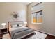 Modern bedroom featuring a tufted headboard, decorative wall mirror, and soft lighting at 6438 E Claire Dr, Scottsdale, AZ 85254