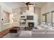 Bright living room with a fireplace, ceiling fan, and large windows, offering a comfortable and stylish space at 6438 E Claire Dr, Scottsdale, AZ 85254