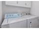 Bright laundry room with washer, dryer and white cabinets for ample storage space at 7500 E Deer Valley Rd # 157, Scottsdale, AZ 85255