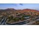 Scenic aerial view of a residential community nestled near mountains, featuring lush greenery and a community pool at 7841 E Stonecliff Cir, Mesa, AZ 85207