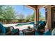 Outdoor patio with ample seating and a stunning view of the pool and lush landscaping at 7841 E Stonecliff Cir, Mesa, AZ 85207