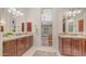 Bathroom with dual sink vanities, tile countertops, and arched doorway at 7841 E Stonecliff Cir, Mesa, AZ 85207