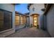 Private courtyard with a stone paver patio, arched doorway and windows, and decorative plants at 7841 E Stonecliff Cir, Mesa, AZ 85207