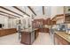 Open kitchen with stainless steel appliances, granite island, custom cabinets and open to living area at 7841 E Stonecliff Cir, Mesa, AZ 85207
