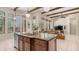 Kitchen island featuring sink, granite counters, seating area, and views to the spacious living area at 7841 E Stonecliff Cir, Mesa, AZ 85207